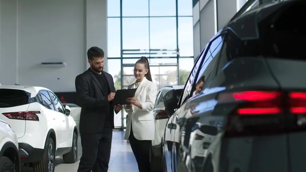 A bearded male chooses a car to rent.