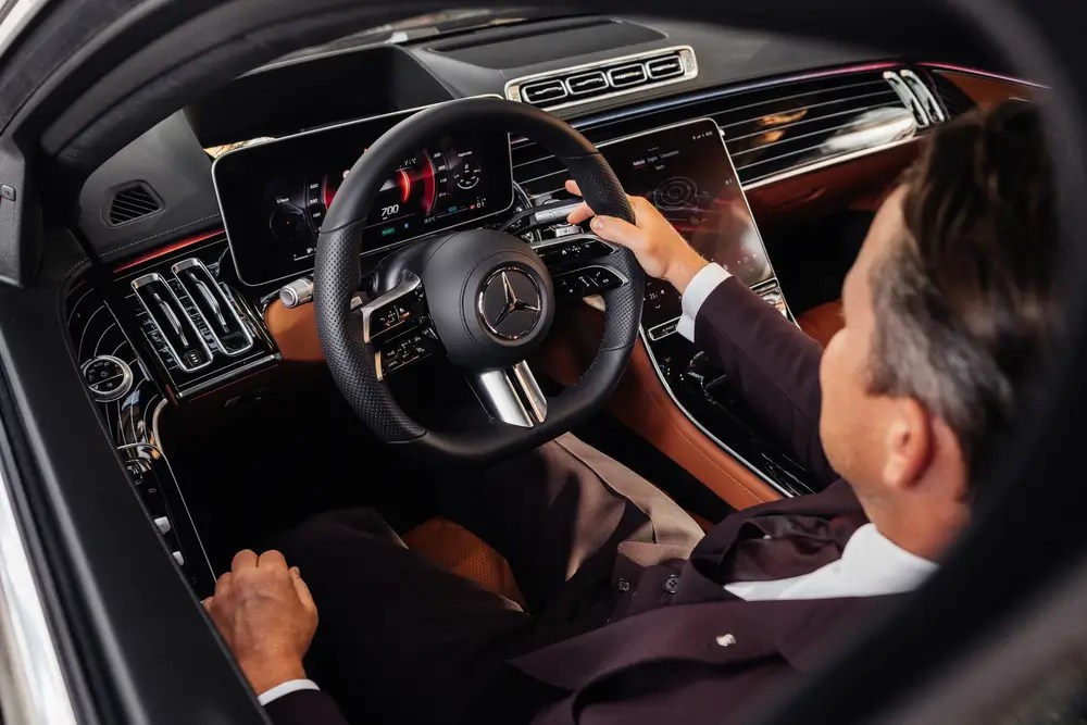 Man sitting in driver seat in luxury car Mercedes benz S class w223